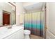 Well-lit bathroom featuring a stylish vanity and colorful shower curtain for a pleasant look at 18221 Thornhill Grand Cir, Orlando, FL 32820