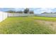 Large, grassy backyard enclosed by a white fence and bright, sunny sky at 1724 Holton Rd, Lakeland, FL 33810