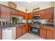 This kitchen features stainless steel appliances, granite countertops, and warm wood cabinetry at 1724 Holton Rd, Lakeland, FL 33810