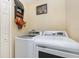 Bright laundry room includes a white washer and dryer with shelving, ample space and neutral colors at 1724 Holton Rd, Lakeland, FL 33810