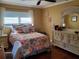 Bedroom with a decorative floral bedspread and matching wood furniture at 2404 Waycross Ave, Eustis, FL 32726