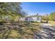 A cozy single-story home featuring a well-kept lawn, bordered by a mix of shrubs and greenery at 1140 Saddlewood Blvd, Lakeland, FL 33809