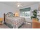 Cozy bedroom with a decorative quilt, ceiling fan, and a window at 2009 Salinas Ave, The Villages, FL 32159