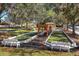 View of the community bocce ball courts, surrounded by benches, trees, and lush landscaping at 2009 Salinas Ave, Lady Lake, FL 32159