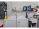 Functional laundry room with white washer and dryer, sink, and ample shelving for storage at 2009 Salinas Ave, The Villages, FL 32159