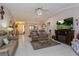 Spacious living room with tile flooring, ceiling fan, comfortable seating, and fireplace with large-screen TV at 2009 Salinas Ave, The Villages, FL 32159