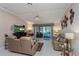 Comfortable living room with plush seating, a ceiling fan, and sliding glass doors leading to an outdoor space at 2009 Salinas Ave, The Villages, FL 32159