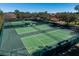 Aerial view of multiple well-maintained community tennis courts with green surfaces and surrounding trees at 2009 Salinas Ave, Lady Lake, FL 32159