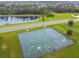 Aerial view of a basketball court near the water, with a paved area and well-maintained landscaping at 2163 Plantation Oak Dr, Orlando, FL 32824