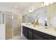 Bathroom featuring dual vanity sinks, a large mirror, and a glass-enclosed shower at 2163 Plantation Oak Dr, Orlando, FL 32824