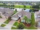 Aerial view of home with lush lawn, decorative shrubbery, and brick-paved driveway, overlooking a pond at 2163 Plantation Oak Dr, Orlando, FL 32824