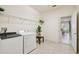 Functional laundry room with white washer, dryer, and storage shelf, plus tile floor at 2163 Plantation Oak Dr, Orlando, FL 32824