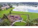 Aerial shot of a fenced-in playground area near the water, featuring a play structure and green space at 2163 Plantation Oak Dr, Orlando, FL 32824