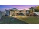 Wide view of a backyard featuring a screened patio at dusk at 5152 Belmont Park Way, Mulberry, FL 33860