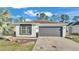 Charming single-story home with a gray two-car garage, well-maintained landscaping and a beautiful palm tree at 5152 Belmont Park Way, Mulberry, FL 33860