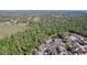 Wide aerial view of a residential community surrounded by lush greenery and a tranquil pond at 6455 Sedgeford Dr, Lakeland, FL 33811