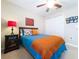 Bedroom with a ceiling fan, closet, bedside table, and colorful decor at 6455 Sedgeford Dr, Lakeland, FL 33811