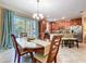 Bright dining area with wood table, kitchen view and large window with nature views at 6455 Sedgeford Dr, Lakeland, FL 33811