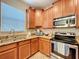 Kitchen featuring wooden cabinets, stainless steel appliances, granite countertops, and natural light at 6455 Sedgeford Dr, Lakeland, FL 33811