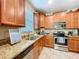 Spacious kitchen featuring wooden cabinets, stainless steel appliances, and granite countertops at 6455 Sedgeford Dr, Lakeland, FL 33811