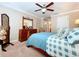 Warm bedroom featuring an ornate headboard, ceiling fan, and natural light from the adjacent spaces at 6455 Sedgeford Dr, Lakeland, FL 33811