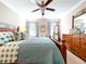 Comfortable primary bedroom with a ceiling fan, dresser with mirror, natural light, and warm accents at 6455 Sedgeford Dr, Lakeland, FL 33811