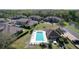 Aerial shot showcasing the community pool with lounge area, tropical landscaping, and surrounding homes at 6455 Sedgeford Dr, Lakeland, FL 33811