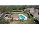 Aerial view of a community pool area with lounge chairs, manicured landscaping, and a nearby clubhouse at 6455 Sedgeford Dr, Lakeland, FL 33811