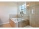 Luxurious bathroom featuring a tub and glass enclosed shower with tiled surround at 9147 Shepton St, Orlando, FL 32825