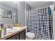 Standard bathroom with single sink vanity, black and white checkered shower curtain, and gray walls at 114 Briarcliff Dr, Kissimmee, FL 34758