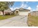 Well-kept single-Gathering home with a spacious driveway and mature tree in the front yard at 114 Briarcliff Dr, Kissimmee, FL 34758