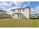 The backyard features green grass, a two story home with white siding and a small covered porch at 2122 Rosewood Dr, Bartow, FL 33830