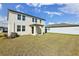 The backyard features green grass, a two story home with white siding, a small porch and a white fence at 2122 Rosewood Dr, Bartow, FL 33830