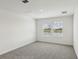 Bright bedroom featuring neutral carpet, two windows, and a view of a serene pond at 2122 Rosewood Dr, Bartow, FL 33830