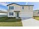 Charming two-story home featuring blue shutters, a well-manicured lawn, and an attached two-car garage at 2122 Rosewood Dr, Bartow, FL 33830