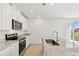 Open kitchen featuring stainless steel appliances, granite countertops, and sliding glass doors to the patio at 2122 Rosewood Dr, Bartow, FL 33830