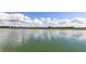 A calming aerial view of the pond and community homes in the distance, under a blue sky and scattered clouds at 2122 Rosewood Dr, Bartow, FL 33830