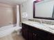 Bathroom showcasing a granite countertop, dark wood cabinets, and tile shower/tub combo at 6337 Parc Corniche Dr # 2101, Orlando, FL 32821