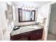Bathroom features granite countertop, cherry wood cabinets, and well-lit vanity mirror with storage at 6337 Parc Corniche Dr # 2101, Orlando, FL 32821