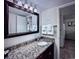 Well-lit bathroom with a vanity featuring a granite countertop, mirror, and fresh towels at 6337 Parc Corniche Dr # 2101, Orlando, FL 32821