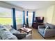 Comfortable living room offers a sofa, armchair, and large windows for natural light, plus a flatscreen TV at 6337 Parc Corniche Dr # 2101, Orlando, FL 32821