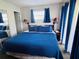 Comfortable main bedroom with a bright blue bedspread and lamps, for a cozy and relaxing retreat at 6337 Parc Corniche Dr # 2101, Orlando, FL 32821