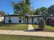Charming single-story home featuring white walls, dark trim, and a well-maintained front lawn at 663 Hager St, Deltona, FL 32725