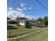 View of the backyard with a well-maintained lawn, small building, carport and wooden fence at 102 Center Sw St, Winter Haven, FL 33880