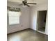 Bedroom features a ceiling fan and window, with an entry to the bathroom at 102 Center Sw St, Winter Haven, FL 33880