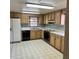 A well-lit kitchen with wooden cabinets, laminate countertops, and black appliances at 102 Center Sw St, Winter Haven, FL 33880