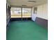 Enclosed patio with screen windows, bench seating, and durable green flooring at 102 Center Sw St, Winter Haven, FL 33880