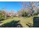 Expansive backyard with lush green grass and mature trees offering ample space for outdoor activities at 211 W Valencia St, Lakeland, FL 33805