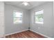 This bedroom features wood floors, two windows letting in lots of natural light, and neutral-colored walls at 211 W Valencia St, Lakeland, FL 33805