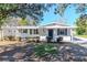 Charming home showcasing blue shutters, manicured bushes, and a well-maintained lawn at 211 W Valencia St, Lakeland, FL 33805